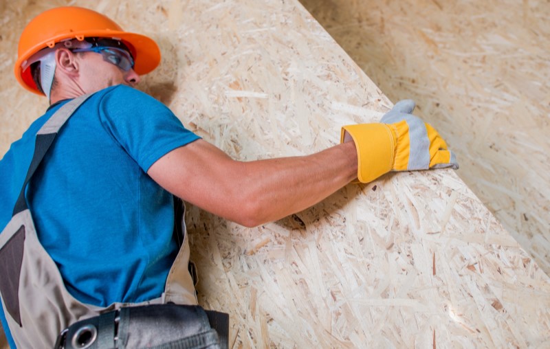 Construção da casa pré-fabricada | Foto de um engenheiro transportando uma placa de OSB | Estilo de vida | Blog Alea