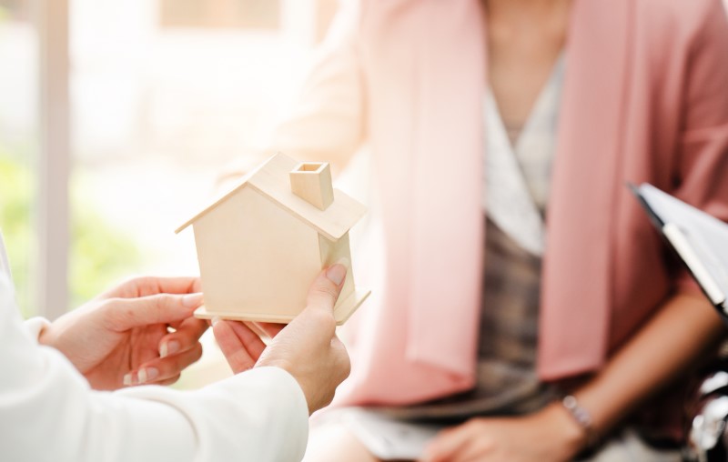 Entrega rápida casa pré-fabricada | Foto de uma corretora mostrando uma miniatura de casa de madeira para uma cliente | Estilo de vida | Blog Alea
