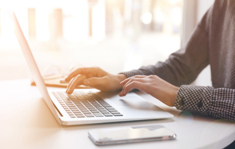 Mãos masculinas digitando em um notebook | Como comprar uma casa pelo Casa Verde e Amarela | Blog Alea