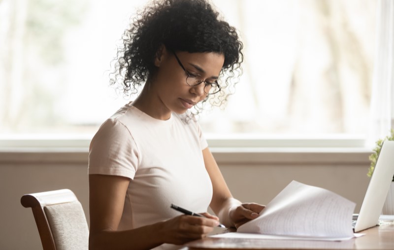 Valor mínimo de entrada para financiar um imóvel | Mulher assinando um contrato | Como comprar uma casa | Blog Alea