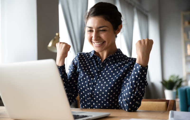 Vantagens do Casa Verde e Amarela | Mulher feliz em frente ao computador | Tudo sobre Casa Verde e Amarela | Blog Alea