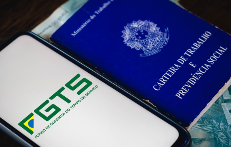 FGTS | Celular com o logo do FGTS e Carteira de Trabalho | Blog Alea