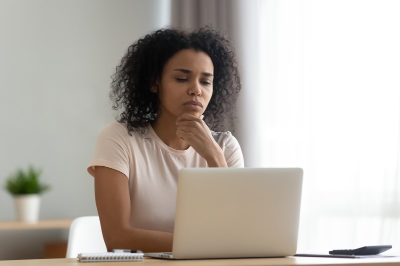 O que é valor venal de imóvel? | Foto de uma mulher com dúvida olhando para o notebook | Como comprar uma casa | Blog Alea