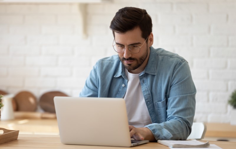 Taxas de financiamento | Homem olhando pensativo para o computador | Como comprar uma casa | Blog Alea