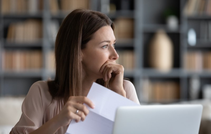 O que acontece se os juros de obra não forem pagos | Mulher preocupada com uma dívida | Como comprar uma casa | Blog Alea