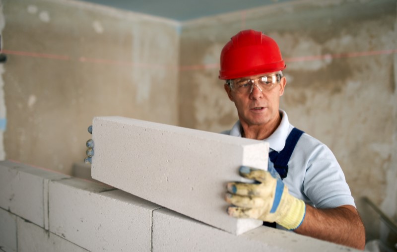 O que é alvenaria | Foto de um pedreiro construindo uma parede de alvenaria | Método Construtivo | Blog Alea