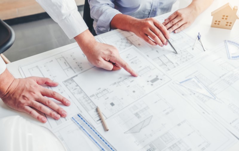 Tipos de alvenaria | Foto de duas pessoas analisando a planta de uma casa | Método Construtivo | Blog Alea