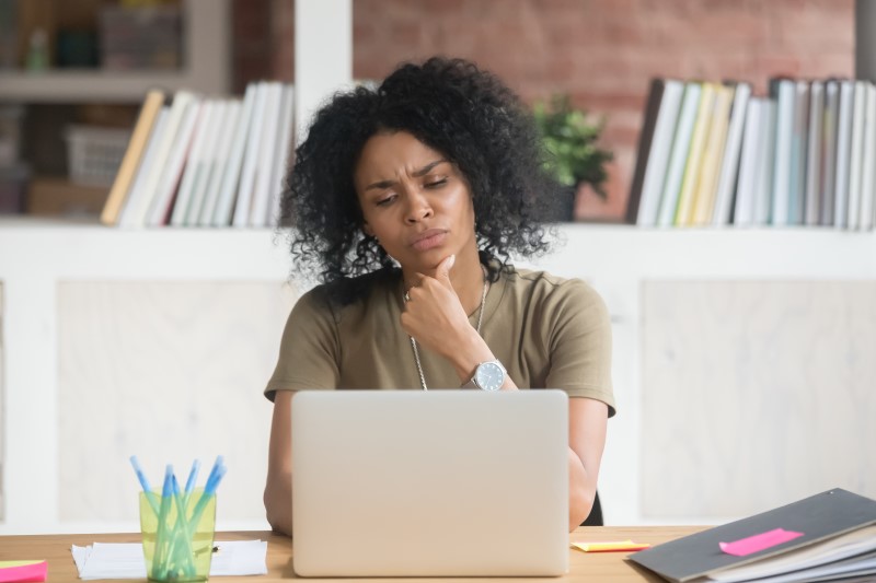 Quem paga o IPTU de imóvel alugado? | Foto de uma mulher com dúvida olhando para o computador | Como comprar uma casa | Blog Alea