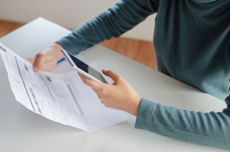 Como pagar o imposto de imóveis | Foto de um homem pagando boleto pelo celular | Como comprar uma casa | Blog Alea