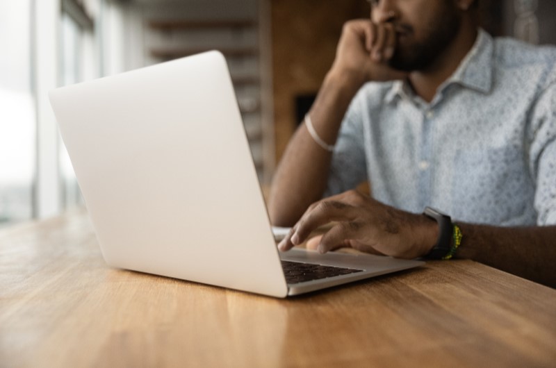 Quem tem direito ao subsídio Minha Casa Minha Vida | Foto de um homem pensativo em frente ao notebook | Tudo sobre Minha Casa Minha Vida | Blog da Alea