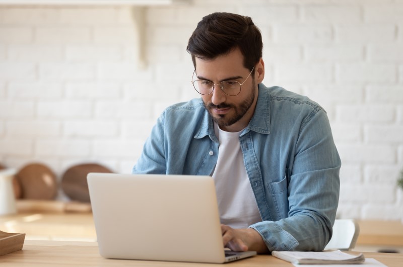 Como se inscrever no Minha Casa Minha Vida | Foto de um homem concentrado usando o notebook | Tudo sobre Minha Casa Minha Vida | Blog Alea