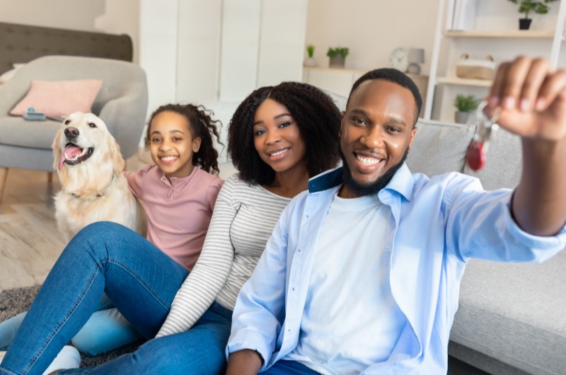 O que é o Minha Casa Minha Vida | Foto de uma familia sorridente e um cachorro, com as chaves da casa própria | Tudo sobre Minha Casa Minha Vida | Blog Alea