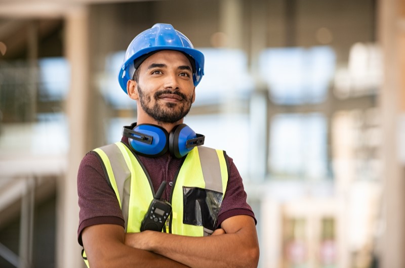Principais tipos de imóveis pré-moldados | Foto de um profissional sorrindo em uma obra | Método Construtivo | Blog Alea
