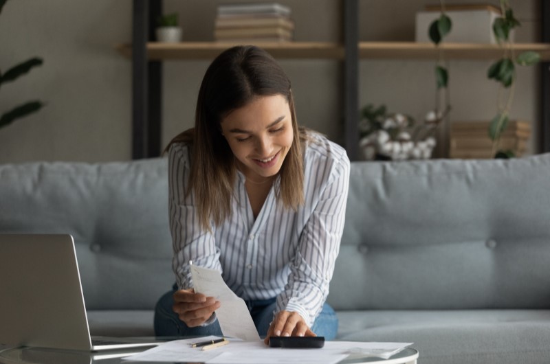 Pesquise e compare os preços | Foto de uma moça segurando um papel e usando a calculadora | Estilo de Vida | Blog Alea