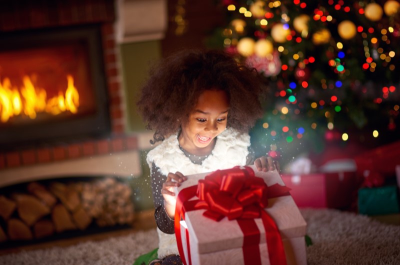 Faça presentes de Natal a mão | Foto de uma criança abrindo um presente de Natal | Estilo de Vida | Blog Alea