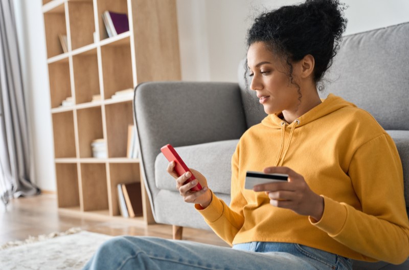 Cuidado ao usar o cartão de crédito | Foto de uma moça segurando o celular e o cartão de crédito | Estilo de Vida | Blog Alea