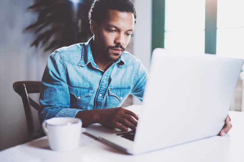Quais são as principais opções para comprar um imóvel? | Foto de um homem pesquisando no notebook | Como comprar uma casa | Blog Alea