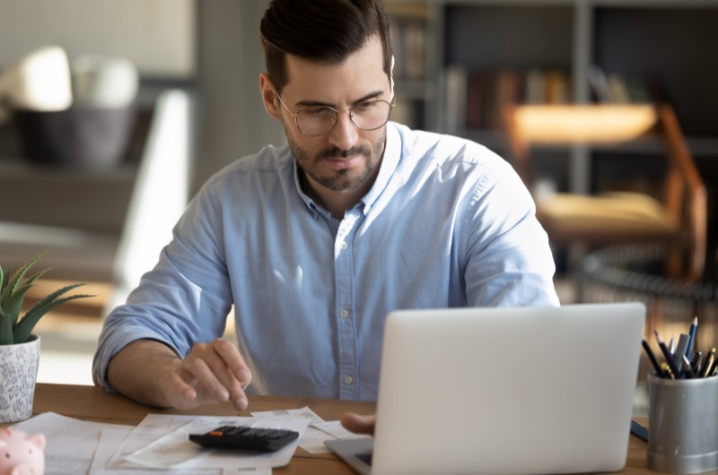 Foto de um homem concentrado olhando para seu notebook | Quando a amortização vale a pena | Como comprar uma casa | Blog Alea