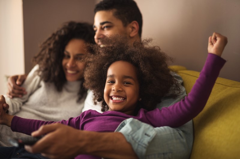 6 Vantagens dos móveis planejados | Foto de uma família feliz sentada no sofá da sala | Estilo de vida | Blog Alea
