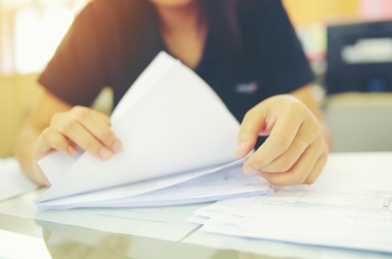 Lista de documentos para escritura de imóvel | Foto de uma pessoa com diversos documentos | Como comprar uma casa | Blog Alea