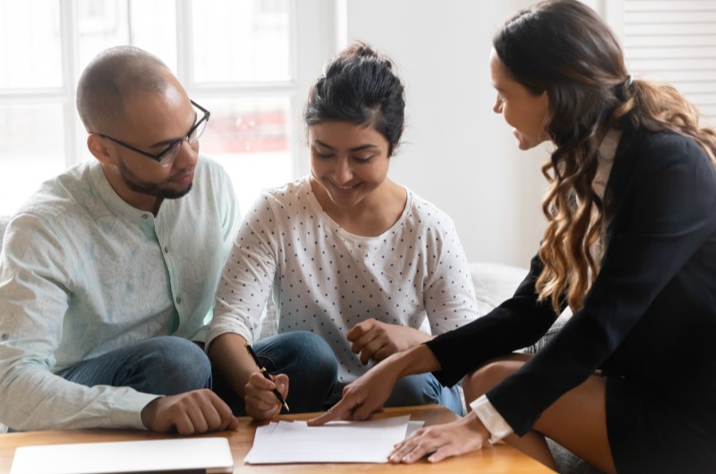 Vantagens do programa | Foto de um casal assinando um contrato de compra de imóve | Tudo sobre o Minha Casa Minha Vida | Blog Alea